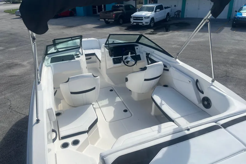 Slide: The Image of 2022 Sea Ray SPX 210 Outboard boat interior with white seating and steering console. - 8