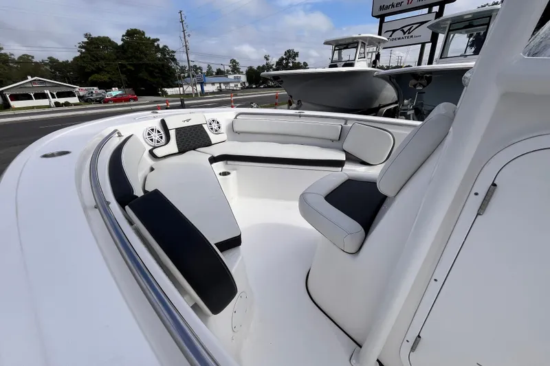 Slide: The Image of 2024 Tidewater 210 LXF boat interior with cushioned seating and speakers. - 11