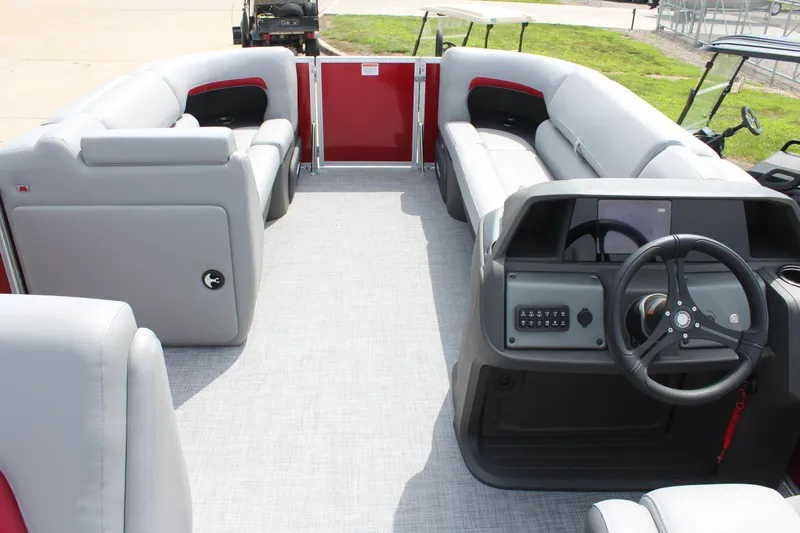 Slide: The Image of 2026 Sun Tracker Party Barge 20 DLX interior with gray seating and steering console. - 10