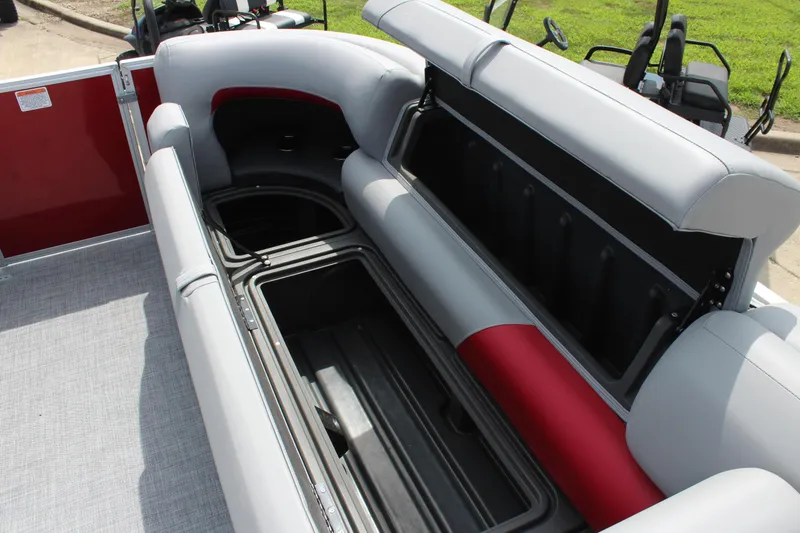 Slide: The Image of 2026 Sun Tracker Party Barge 20 DLX pontoon boat with open storage compartment and cushioned seating. - 15