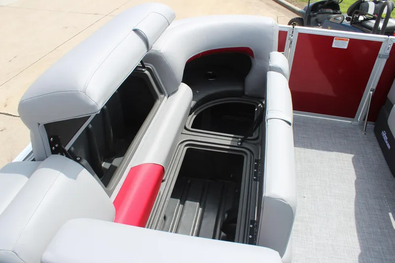 Slide: The Image of 2026 Sun Tracker Party Barge 20 DLX interior seating with storage compartments open. - 16