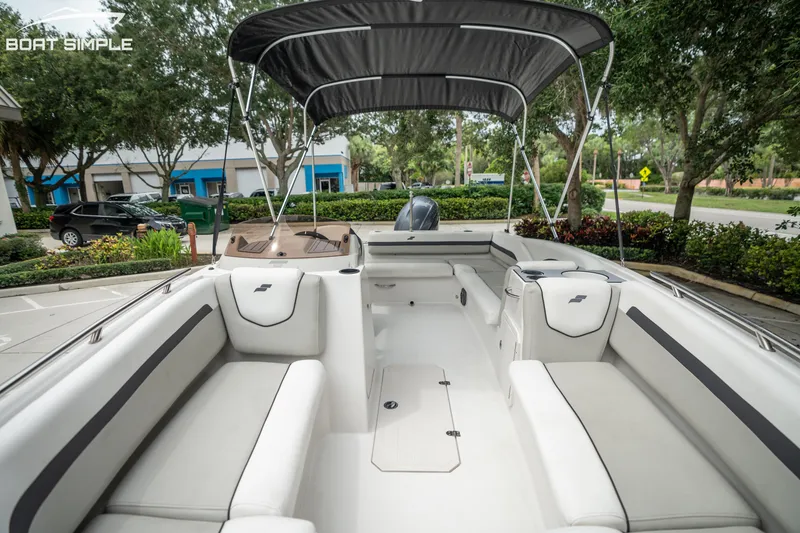 Slide: The Image of 2024 Starcraft SVX 191 OB boat interior with white seating and canopy, parked outdoors. - 10