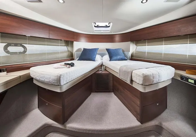 Slide: The Image of Luxurious 2025 Princess 50 Flybridge yacht cabin with twin beds and elegant wood finish. - 17