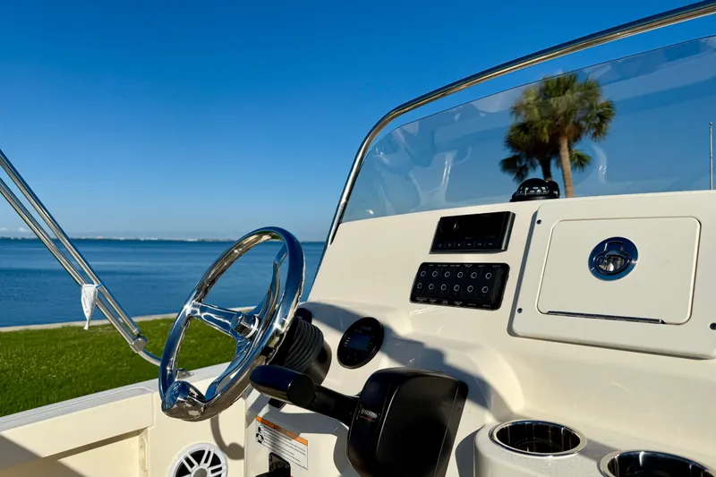 Slide: The Image of 2026 Scout 188 Sportfish boat dashboard with steering wheel, controls, and ocean view. - 11