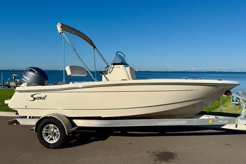Slide: The Image of 2026 Scout 188 Sportfish boat on trailer by the waterfront. - 2
