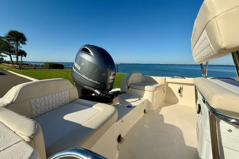 Slide: The Image of 2026 Scout 188 Sportfish boat with Yamaha engine, docked by a scenic waterfront. - 7