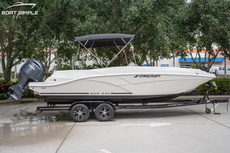 Slide: The Image of 2023 Starcraft SVX 231 OB DH boat on trailer, parked outdoors. - 1