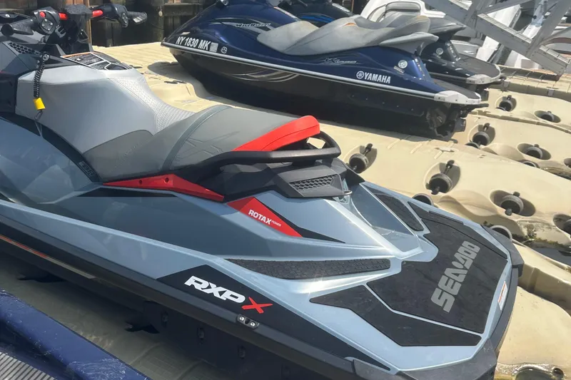 Slide: The Image of 2018 Sea-Doo RXP-X 300 jet ski docked alongside other watercraft. - 2