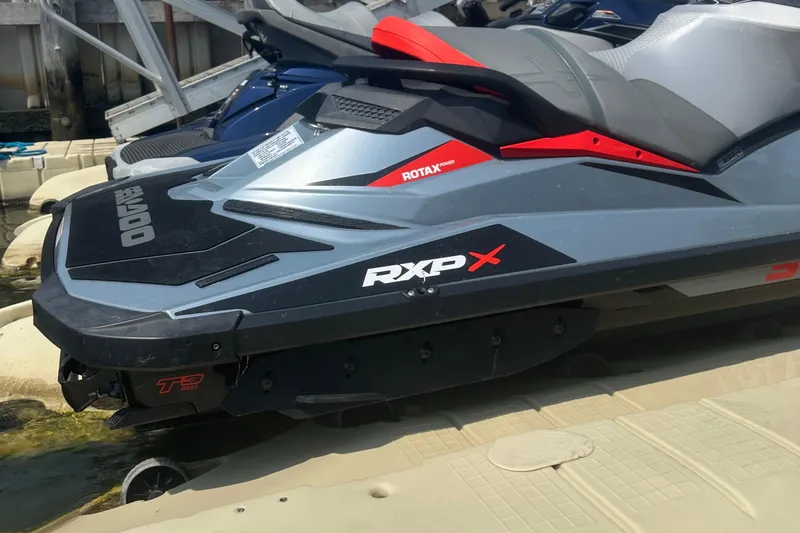 Slide: The Image of 2018 Sea-Doo RXP-X 300 jet ski docked, showcasing sleek design and branding. - 7