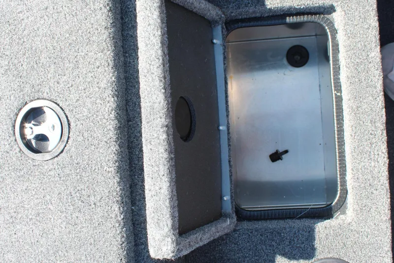 Slide: The Image of Open storage compartment in 2026 Tracker Pro Team 195 boat, featuring carpeted interior. - 18