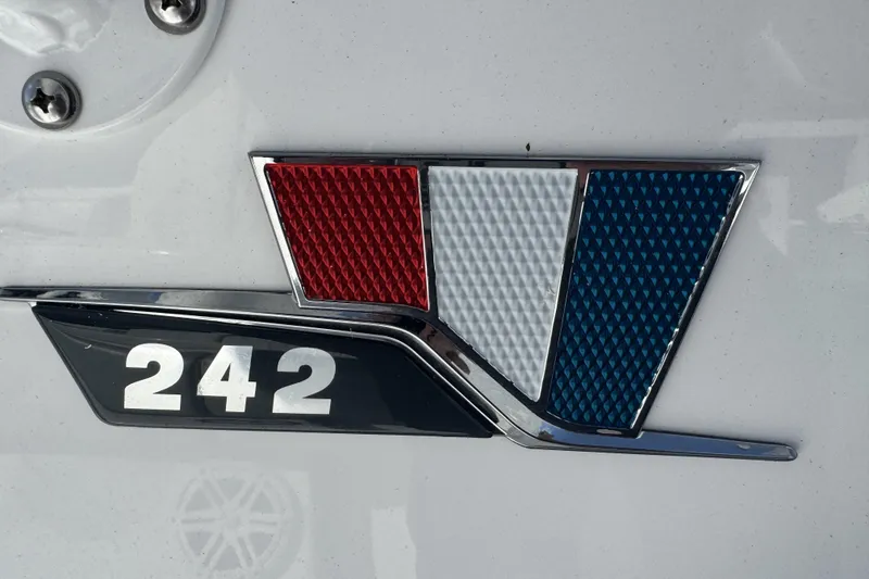 Slide: The Image of 2025 Wellcraft 242 Fisherman emblem with red, white, and blue design. - 12