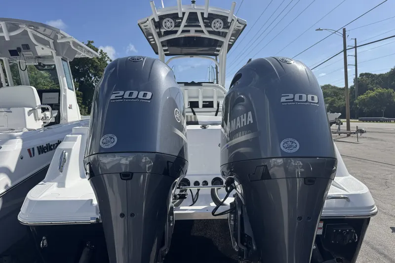 Slide: The Image of 2025 Wellcraft 242 Fisherman boat with dual Yamaha 200 engines, parked outdoors. - 3