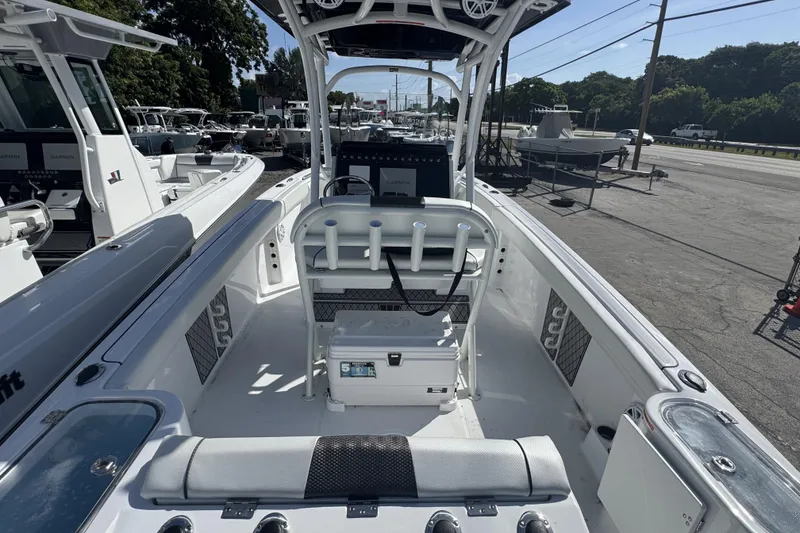 Slide: The Image of 2025 Wellcraft 242 Fisherman boat interior with seating and console, docked outdoors. - 4