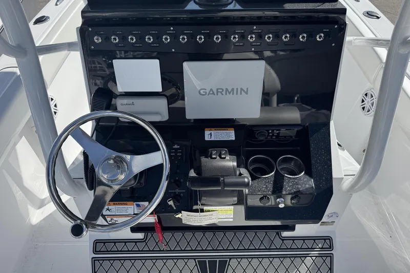 Slide: The Image of 2025 Wellcraft 242 Fisherman boat dashboard with Garmin navigation system and steering wheel. - 6