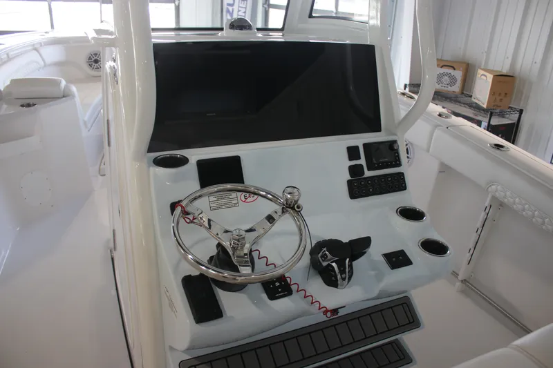 Slide: The Image of 2026 Tidewater 282 CC Adventure boat helm with steering wheel and control panel. - 10
