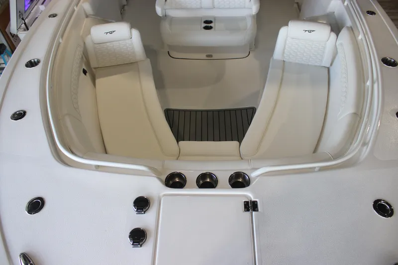 Slide: The Image of 2026 Tidewater 282 CC Adventure boat interior with white seating and cup holders. - 12
