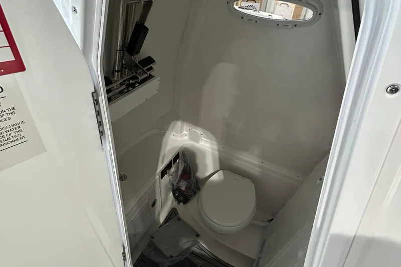 Slide: The Image of Interior of 2026 Tidewater 282 CC Adventure boat, featuring a compact marine toilet. - 2