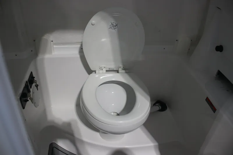 Slide: The Image of 2026 Tidewater 282 CC Adventure boat interior with a compact marine toilet. - 23