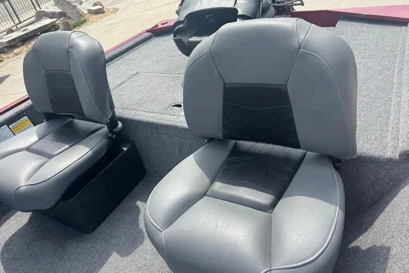 Slide: The Image of 2024 Bass Tracker Classic XL boat seats, gray and black upholstery, outdoor setting. - 11