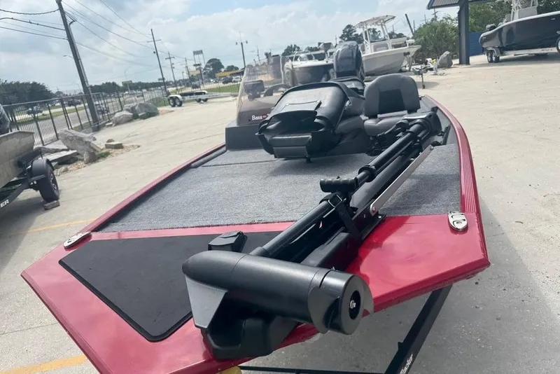 Slide: The Image of 2024 Bass Tracker Classic XL boat with red exterior, parked outdoors. - 8
