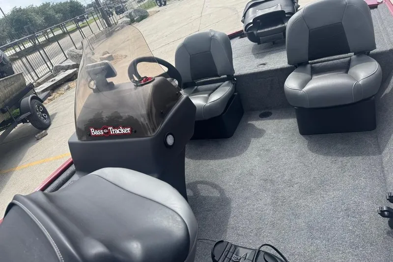 Slide: The Image of 2024 Bass Tracker Classic XL boat interior with gray seating and steering console. - 9