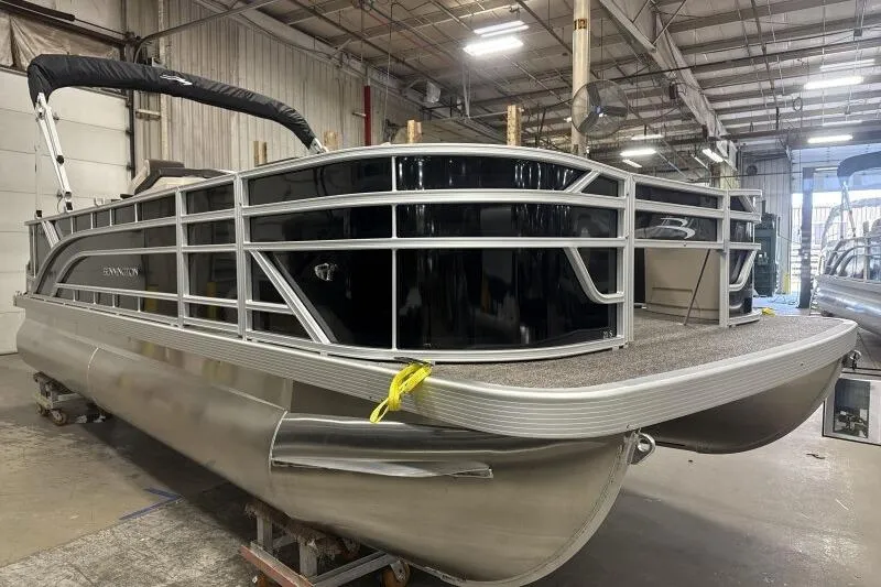 Slide: The Image of 2025 Bennington 21 SF pontoon boat in a warehouse setting. - 11
