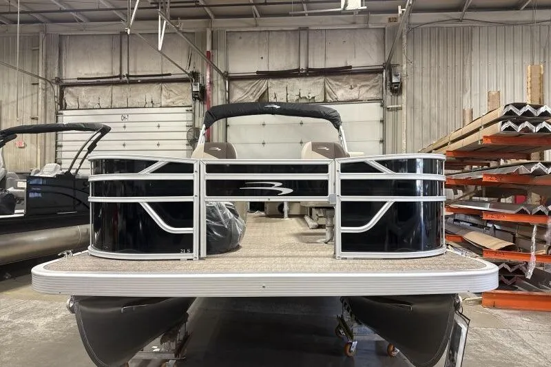 Slide: The Image of 2025 Bennington 21 SF pontoon boat in a warehouse setting. - 2