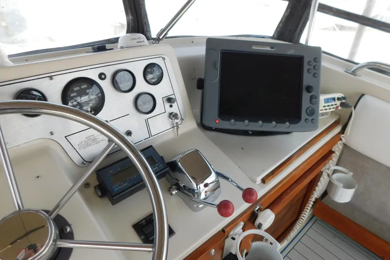 Slide: The Image of 1987 Mainship 40 DC helm with steering wheel, gauges, and navigation equipment. - 15
