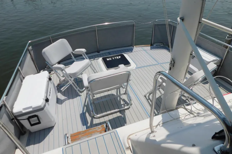 Slide: The Image of 1987 Mainship 40 DC boat deck with chairs and cooler on calm water. - 19
