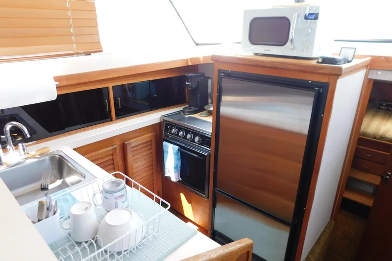 Slide: The Image of 1987 Mainship 40 DC yacht kitchen with sink, stove, fridge, and microwave. - 25