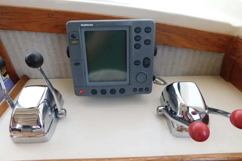 Slide: The Image of Control panel of a 1987 Mainship 40 DC with Raytheon display and throttle levers. - 26