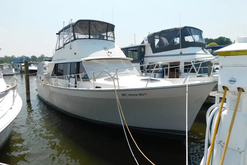 Slide: The Image of 1987 Mainship 40 DC yacht docked at marina, featuring spacious deck and cabin. - 40