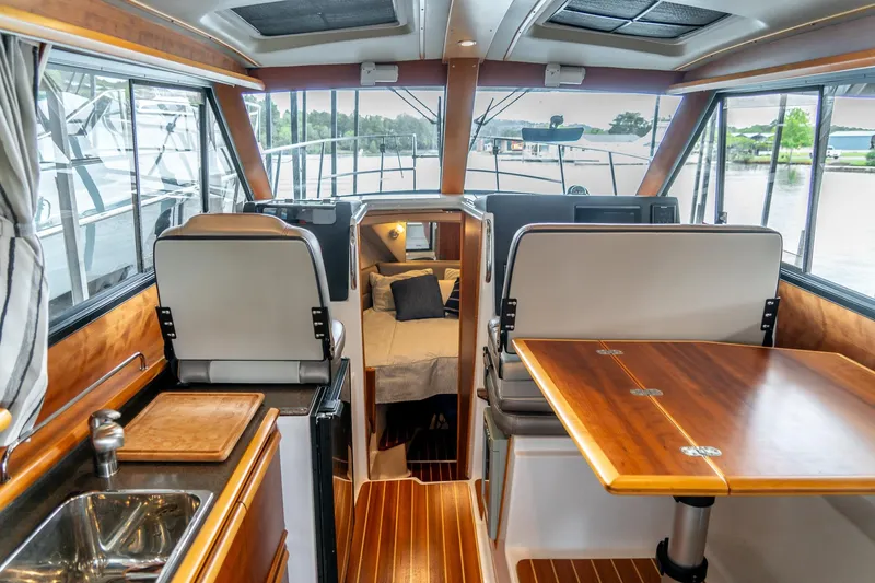 Slide: The Image of 2020 Cutwater C28 interior with wood accents, dining area, and cozy cabin. - 17