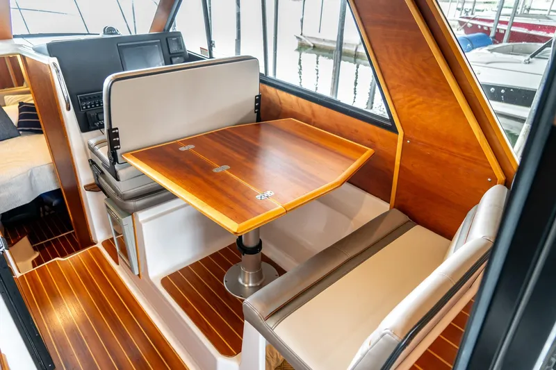 Slide: The Image of 2020 Cutwater C28 boat interior with wooden table and seating area. - 18