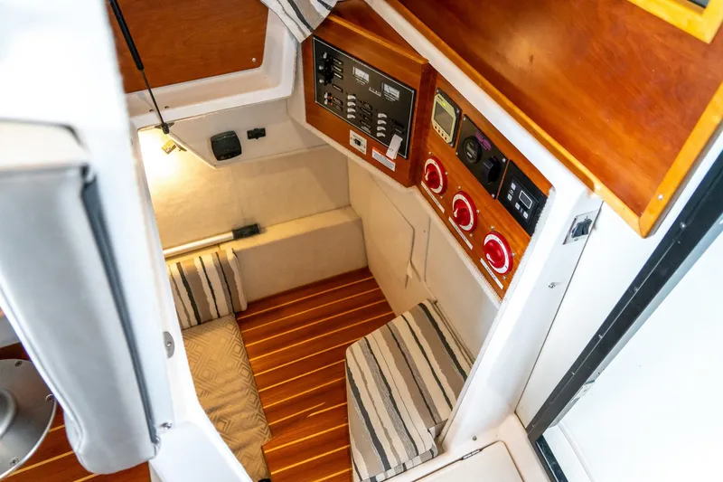 Slide: The Image of 2020 Cutwater C28 cabin interior with control panel and striped cushions. - 20