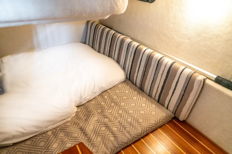 Slide: The Image of Cozy cabin interior of 2020 Cutwater C28 boat with striped cushions and wooden flooring. - 21