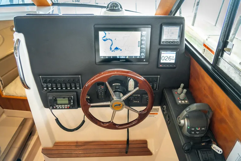 Slide: The Image of 2020 Cutwater C28 helm with navigation display, controls, and wooden steering wheel. - 27