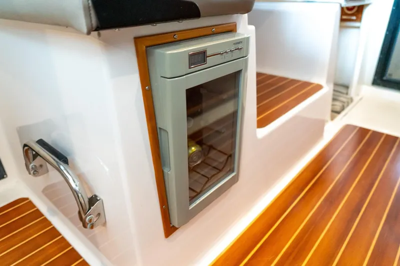 Slide: The Image of 2020 Cutwater C28 interior with built-in mini fridge and wooden flooring. - 34