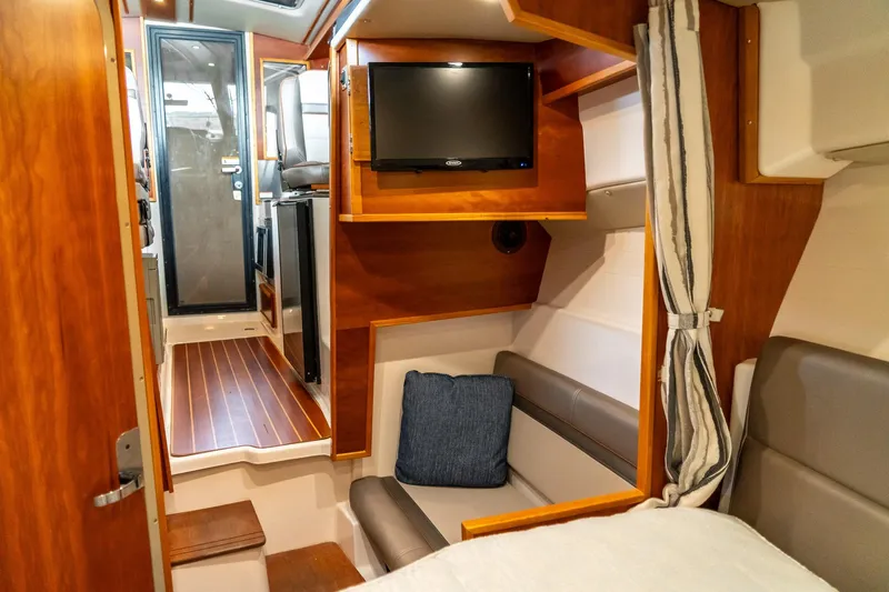 Slide: The Image of 2020 Cutwater C28 interior with cozy seating, TV, and wooden accents. - 37