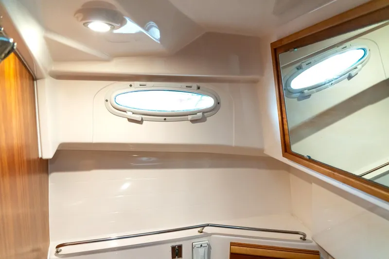 Slide: The Image of 2020 Cutwater C28 boat interior with porthole and mirror in bathroom. - 39