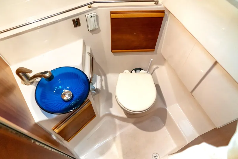 Slide: The Image of 2020 Cutwater C28 boat bathroom with blue glass sink and compact toilet. - 40