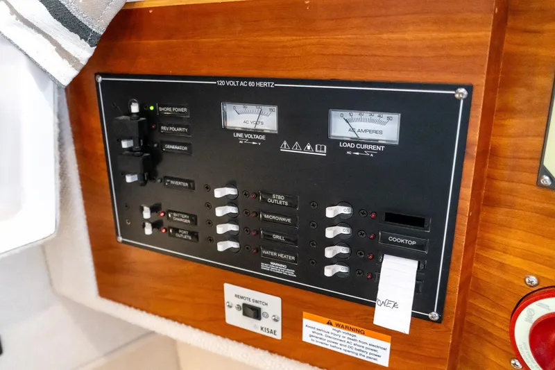 Slide: The Image of Electrical control panel on a 2020 Cutwater C28 boat, featuring various switches and meters. - 44