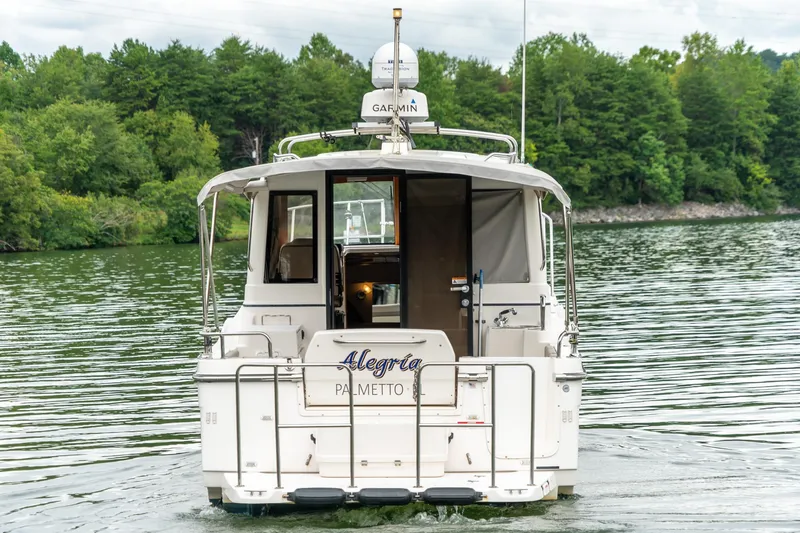 Slide: The Image of 2020 Cutwater C28 boat on a serene lake with lush green forest backdrop. - 6