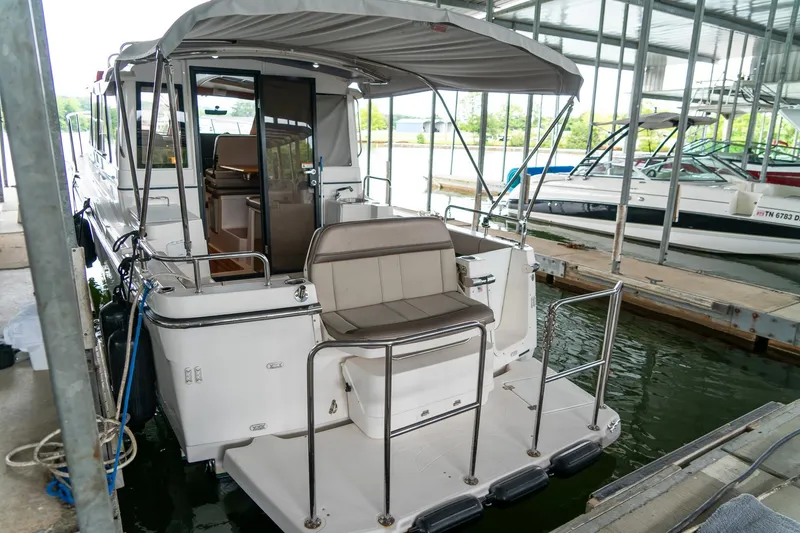 Slide: The Image of 2020 Cutwater C28 boat docked in a marina, featuring a covered seating area. - 7