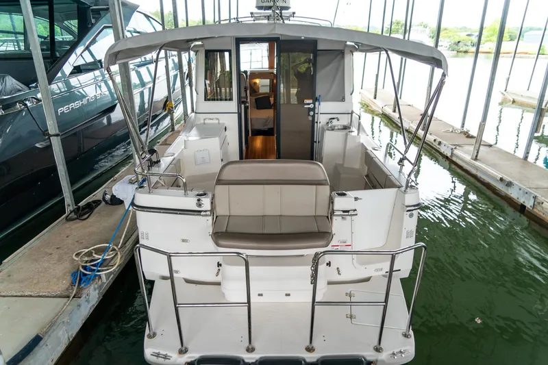 Slide: The Image of 2020 Cutwater C28 boat docked in marina, rear view showing seating and interior. - 8