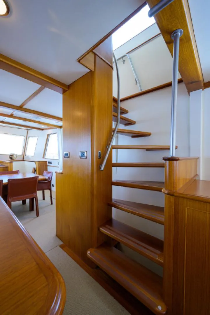 Slide: The Image of Interior of 2003 New England Boatworks Enclosed Raised Pilothouse with wooden staircase and seating area. - 12