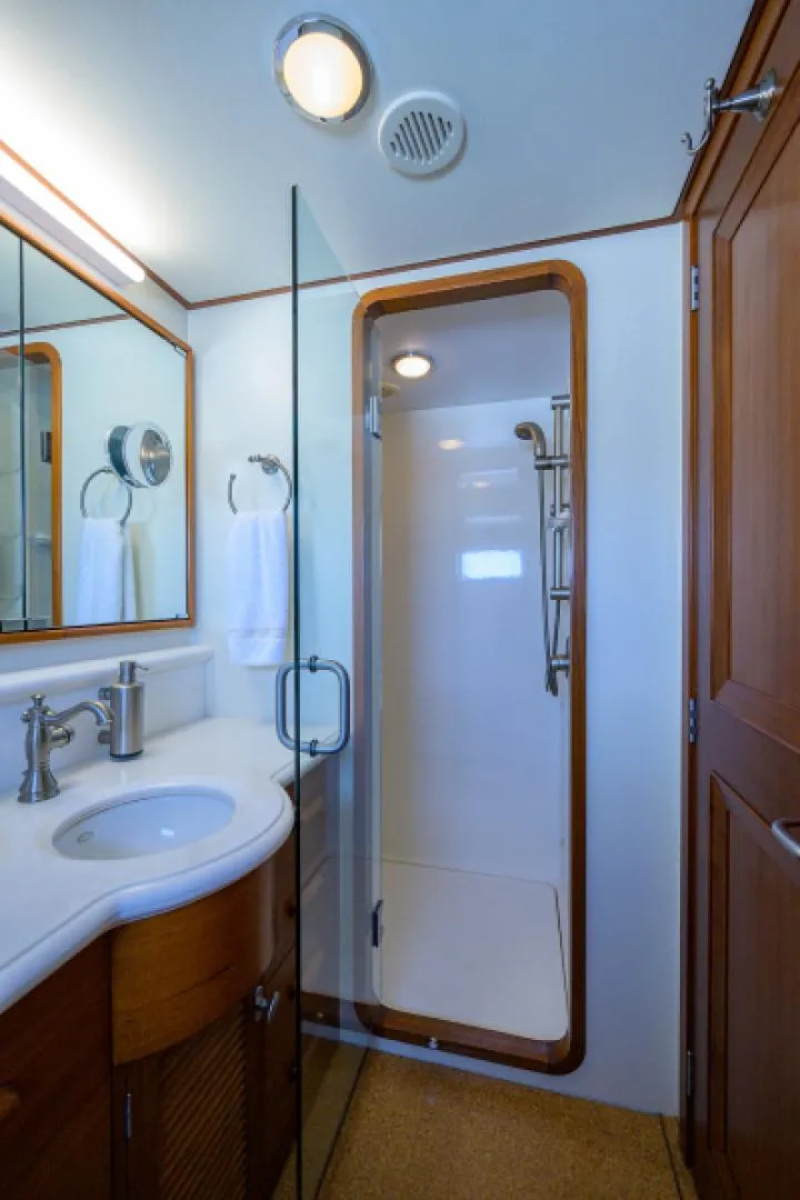 Slide: The Image of Luxurious 2003 New England Boatworks bathroom with shower, sink, and wooden cabinetry. - 25