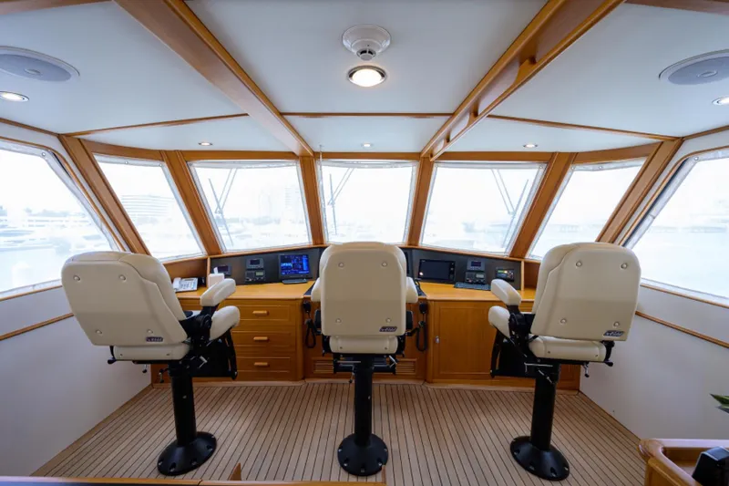Slide: The Image of Enclosed raised pilothouse interior of 2003 New England Boatworks yacht, featuring three captain chairs. - 37