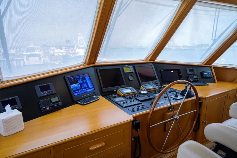 Slide: The Image of Enclosed pilothouse of 2003 New England Boatworks yacht with navigation equipment and wooden steering wheel. - 39