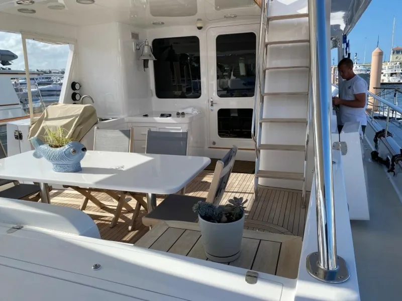 Slide: The Image of Enclosed Raised Pilothouse yacht deck with dining area, stairs, and marina view. - 5